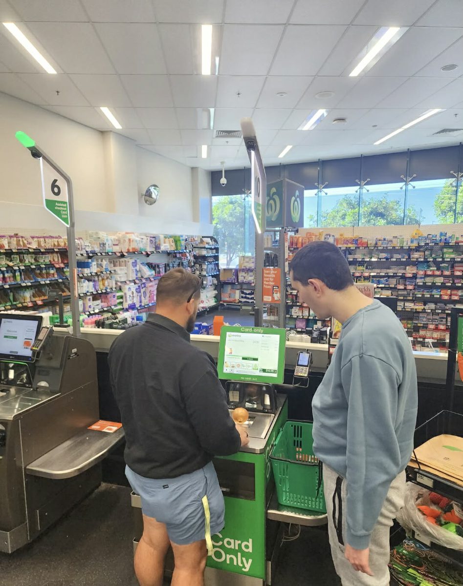 A support worker helping a participant at a supermarket self-checkout