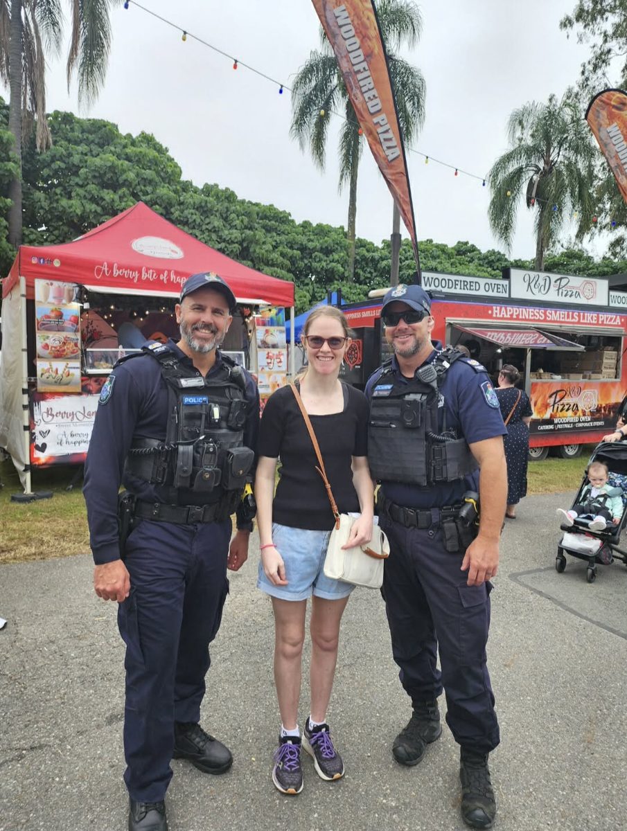 A participant with two Queensland police officers at a community market
