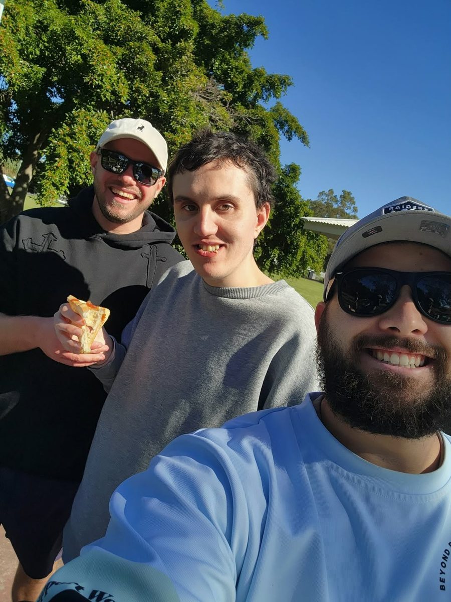 A support worker and two participants taking a selfie at a park