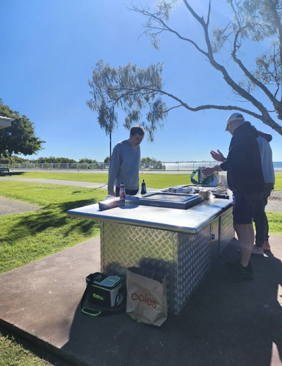 A support worker and participant at a barbecue by the bay