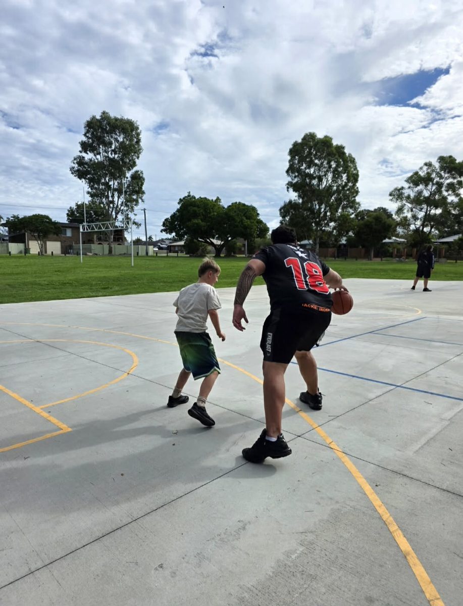 A support worker and participant playing basketball