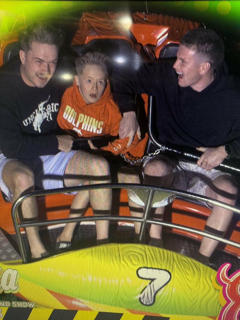 A support worker and participant enjoying a theme park ride