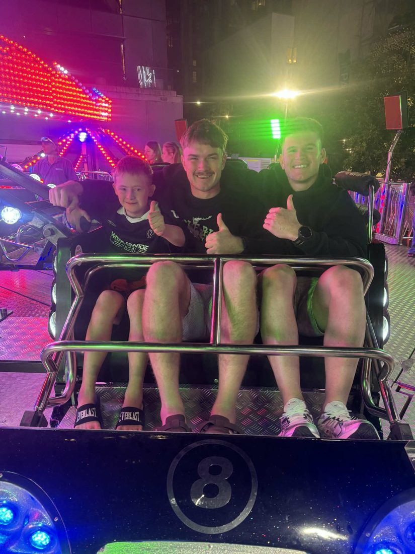 Participants and a support worker on an arcade ride