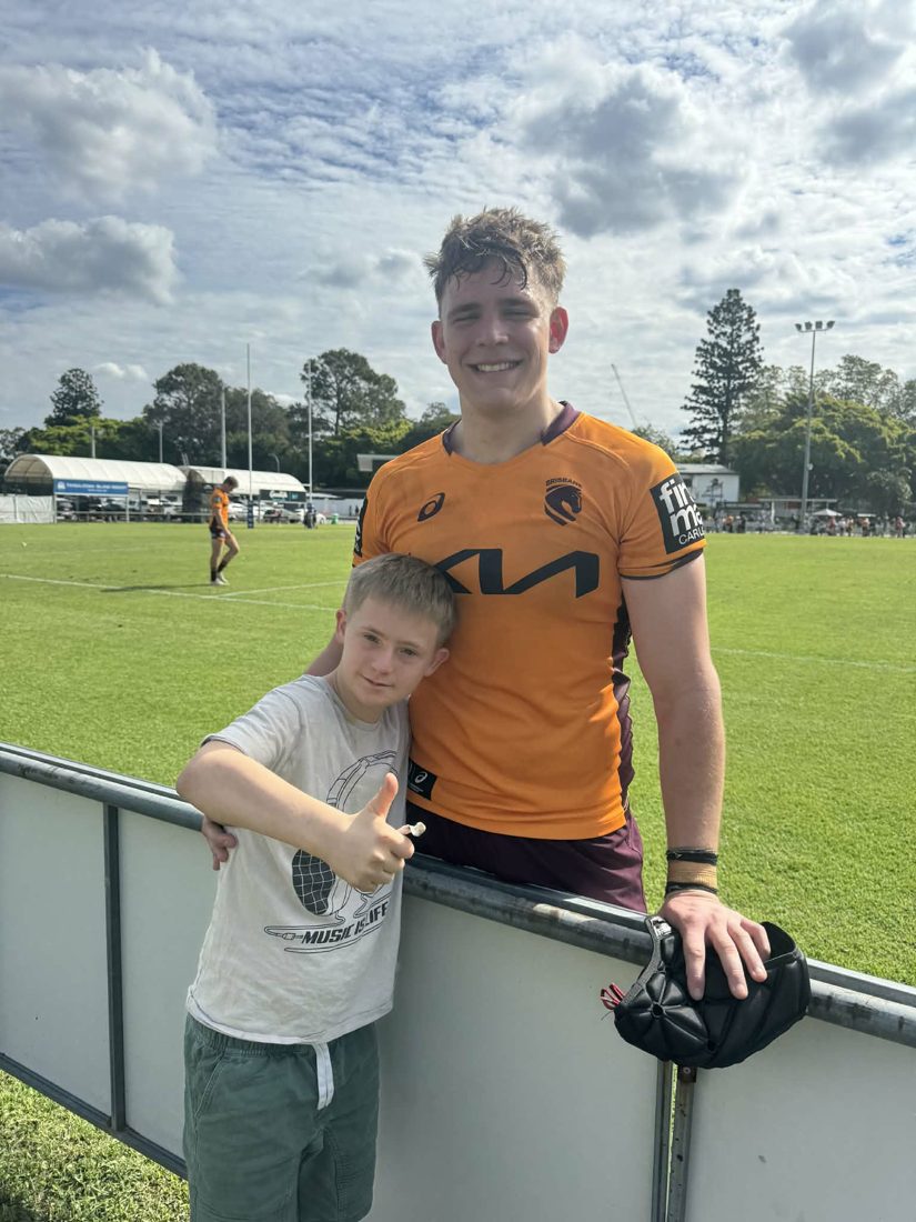 A support worker and participant at a footy field